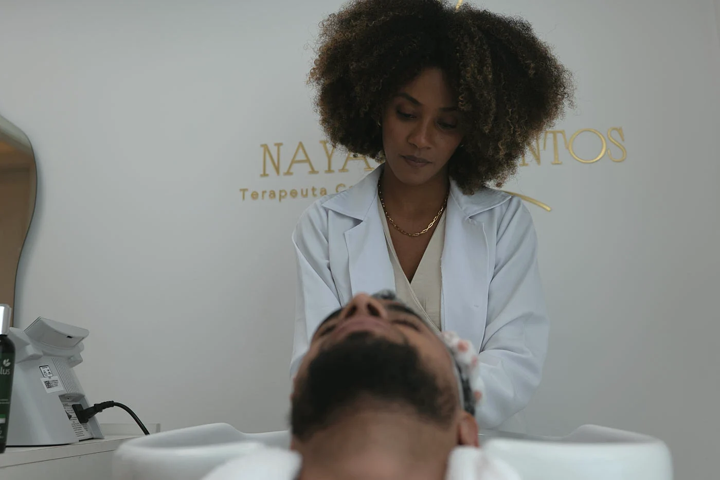 Nayara realizando um cuidado capilar em um cliente
